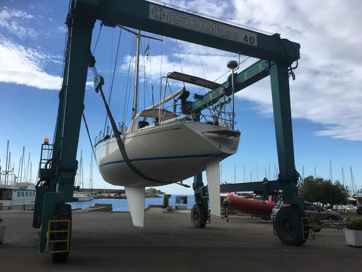  Yacht Photos Pics Nautor Swan 42 sailboat from 1983 being lifted by a crane at a marina.