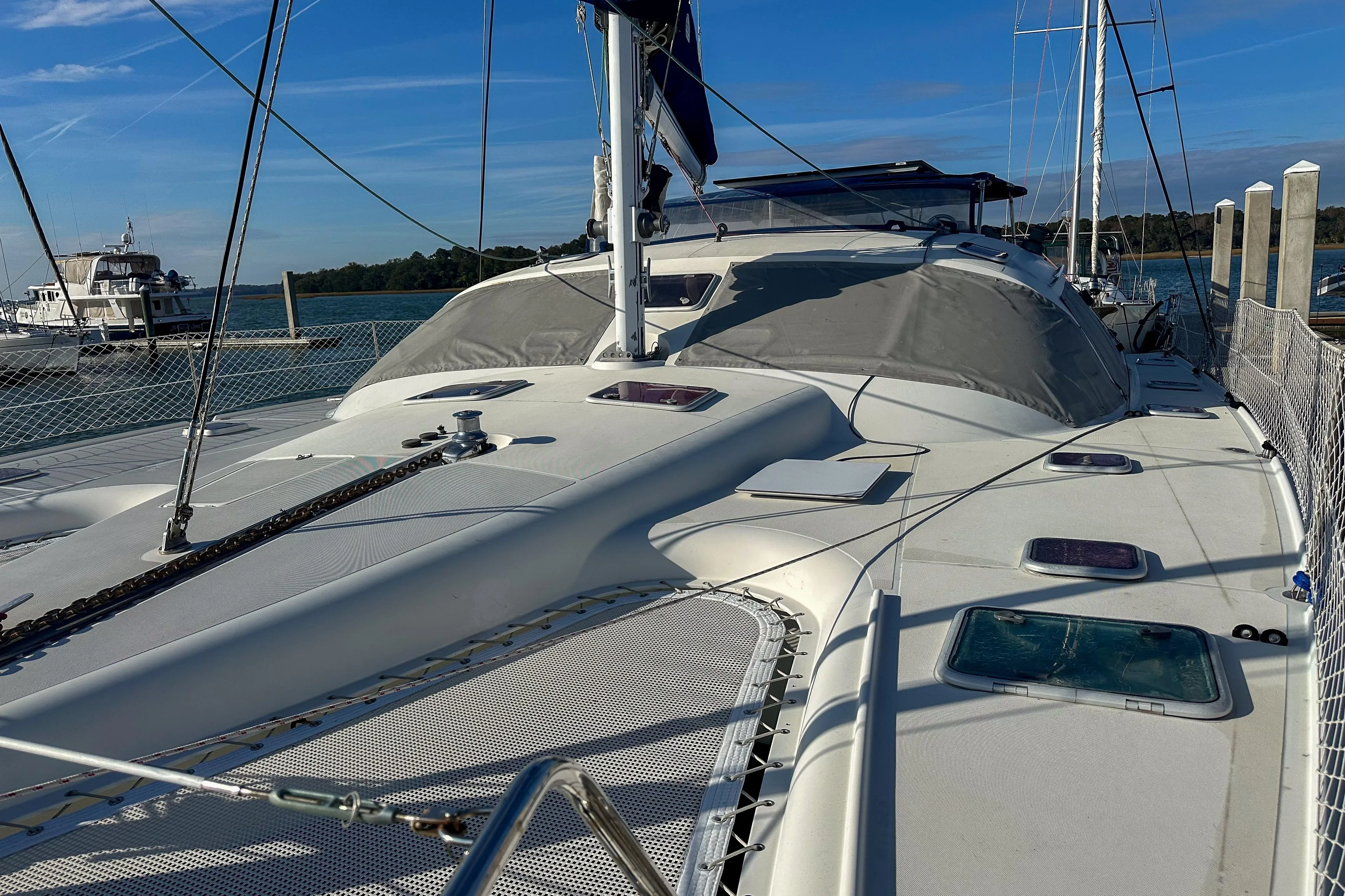 Sailing catamaran Privilege 435, 2001 model, docked at marina under clear blue sky.