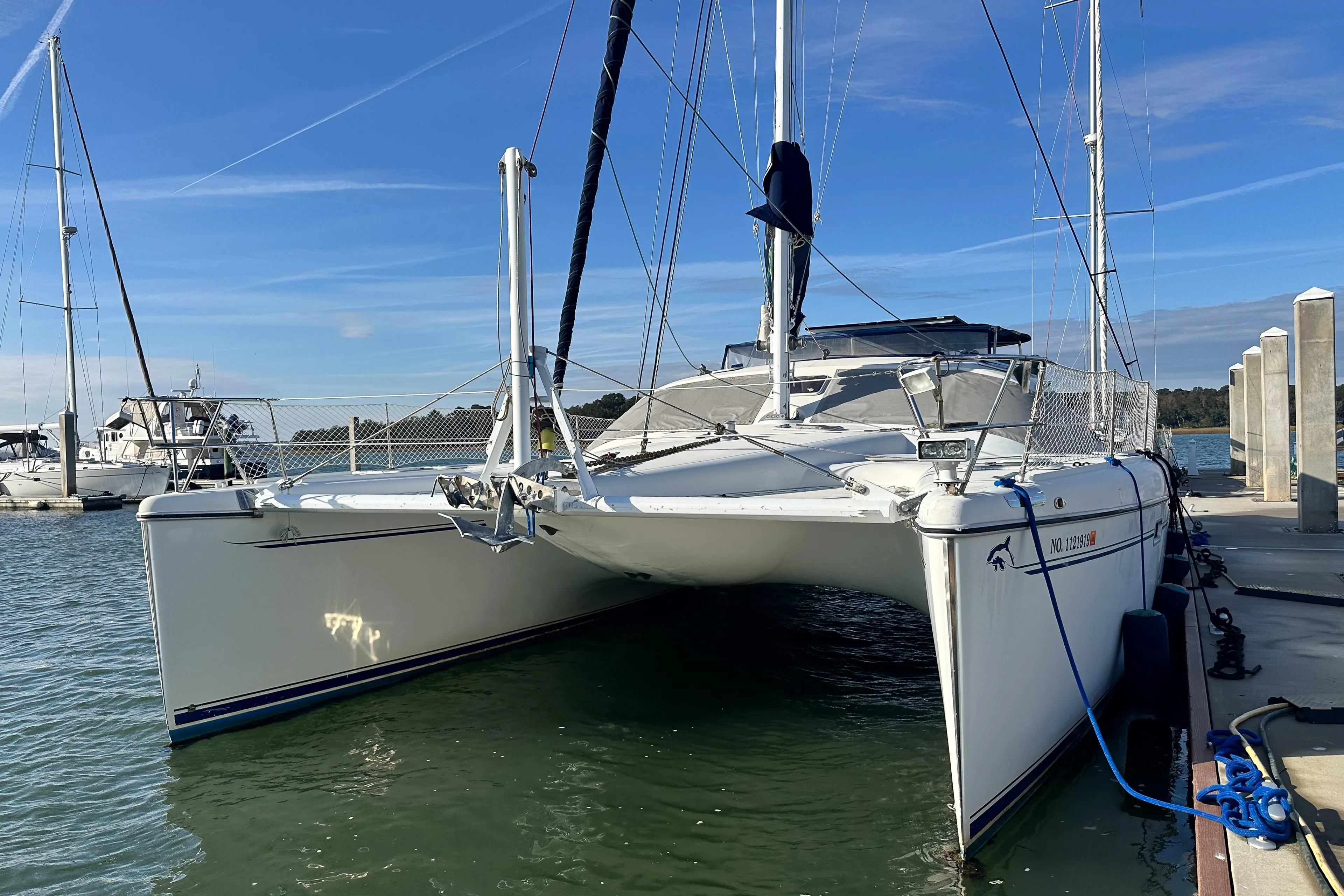 2001 Privilege 435 catamaran docked at marina under clear blue sky.