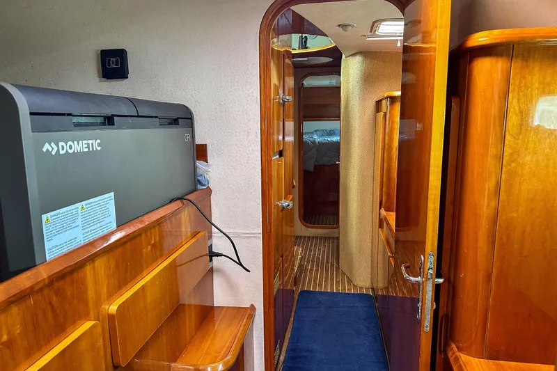Mystic Yacht Photos Pics Interior of a 2001 Privilege 435 yacht with wooden cabinetry and a Dometic CFX cooler.
