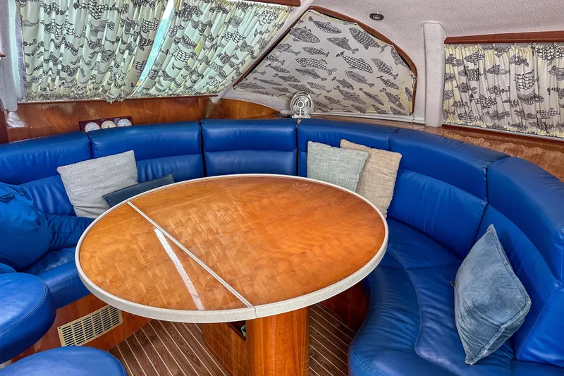 Mystic Yacht Photos Pics Luxurious 2001 Privilege 435 yacht interior with blue seating and wooden table.