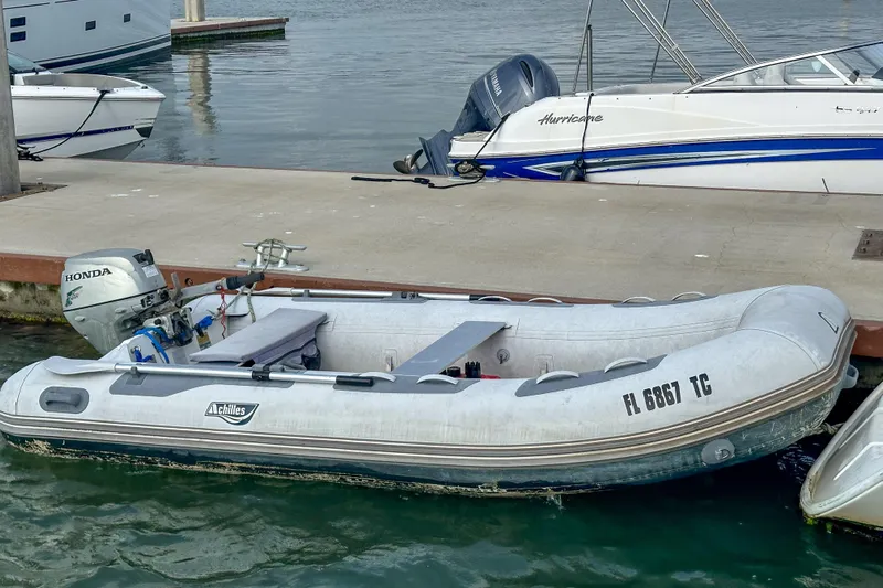 Mystic Yacht Photos Pics Inflatable boat docked beside a pier, featuring a Honda outboard motor.