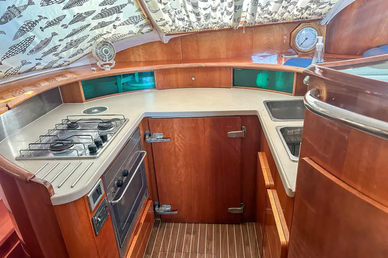 Mystic Yacht Photos Pics Luxurious 2001 Privilege 435 yacht kitchen with stove, oven, and wooden cabinetry.