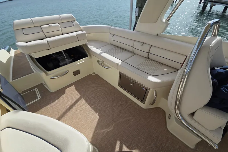  Yacht Photos Pics 2023 Chris-Craft Launch 28 GT interior with luxurious seating and storage, docked by the water.