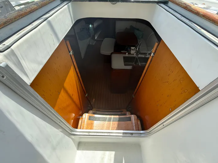 Traveler Yacht Photos Pics Interior view of 2002 Beneteau 473 sailboat, showing wooden stairs and cabin entrance.