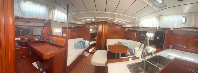 Traveler Yacht Photos Pics Interior of 2002 Beneteau 473 yacht with wood finish, dining area, and navigation station.
