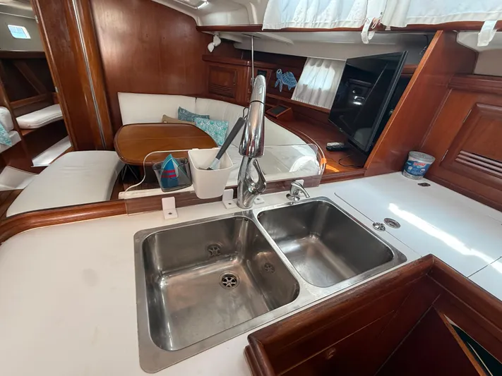 Traveler Yacht Photos Pics Interior of 2002 Beneteau 473 yacht with kitchen sink and dining area.