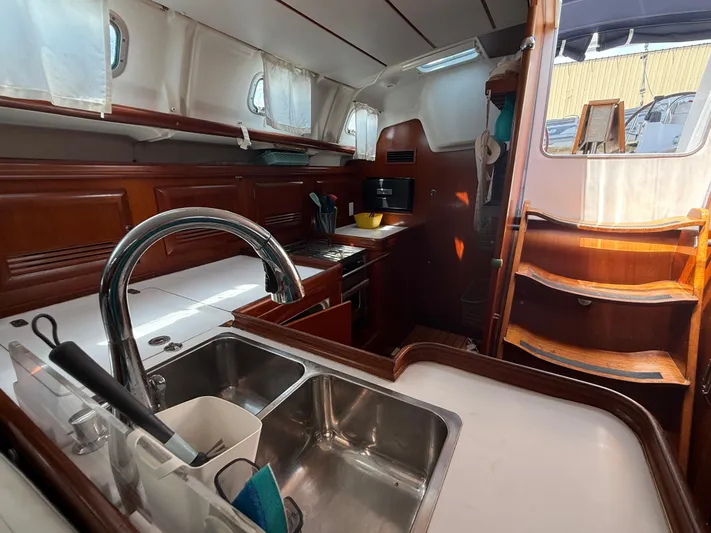 Traveler Yacht Photos Pics Interior of 2002 Beneteau 473 sailboat, featuring a modern kitchen and wooden cabinetry.