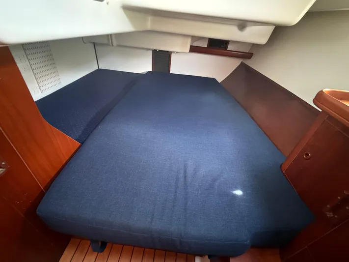 Traveler Yacht Photos Pics Cozy cabin interior of 2002 Beneteau 473 sailboat with blue mattress and wooden accents.