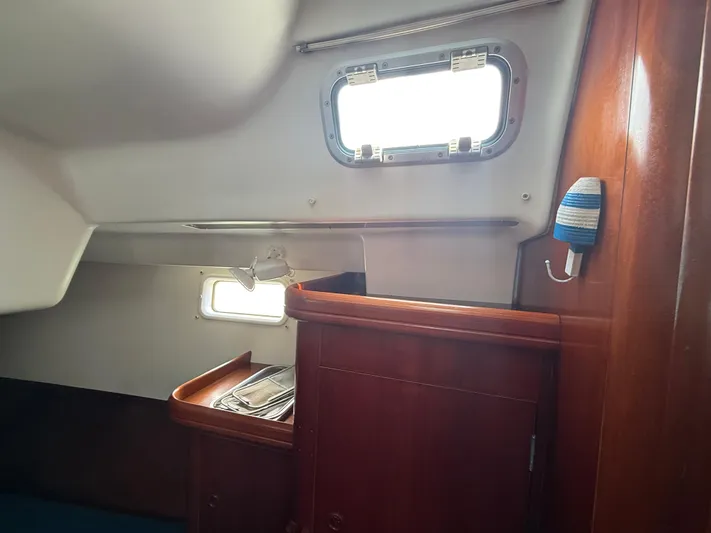 Traveler Yacht Photos Pics Interior cabin of 2002 Beneteau 473 sailboat with wooden cabinetry and porthole windows.
