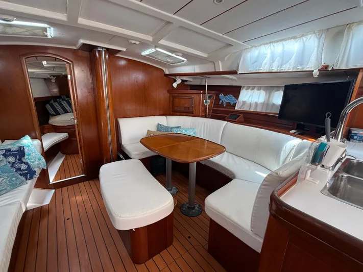 Traveler Yacht Photos Pics Luxurious interior of 2002 Beneteau 473 yacht with elegant wood finish and cozy seating.