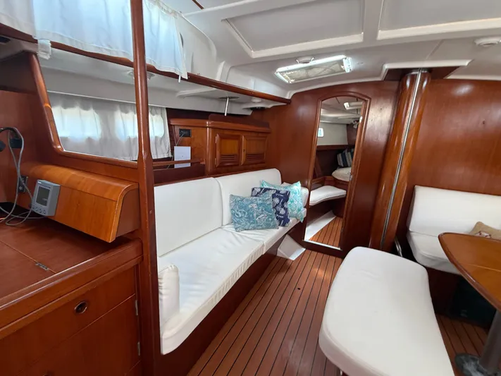 Traveler Yacht Photos Pics Interior of 2002 Beneteau 473 yacht with wooden finish and white seating.