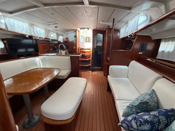 Traveler Yacht Photos Pics Interior of 2002 Beneteau 473 yacht with elegant wood finish and white seating.