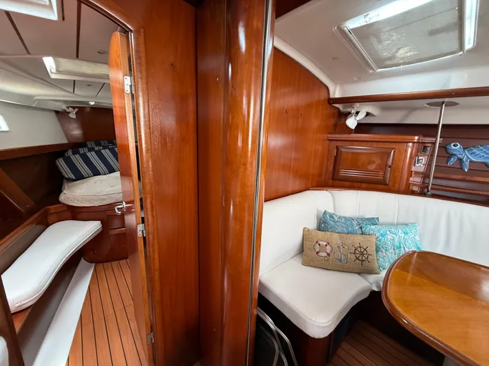 Traveler Yacht Photos Pics Interior of 2002 Beneteau 473 sailboat with wood finish and cozy seating area.