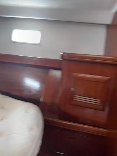 Traveler Yacht Photos Pics Interior of 2002 Beneteau 473 yacht with wooden paneling and cushioned seating.