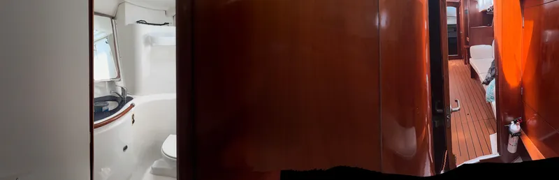 Traveler Yacht Photos Pics Interior of 2002 Beneteau 473 yacht, featuring wooden paneling and a compact bathroom.