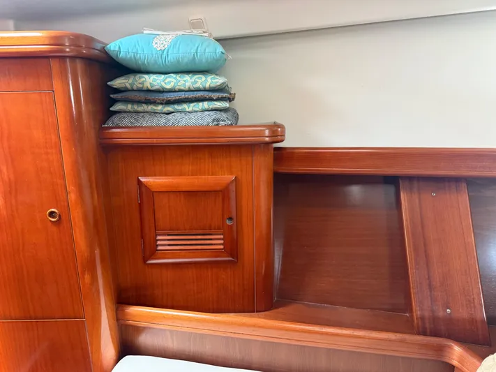 Traveler Yacht Photos Pics Interior of 2002 Beneteau 473 yacht with wooden cabinetry and stacked decorative cushions.