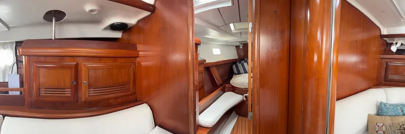 Traveler Yacht Photos Pics Interior of 2002 Beneteau 473 yacht, featuring polished wood cabinetry and cozy seating area.