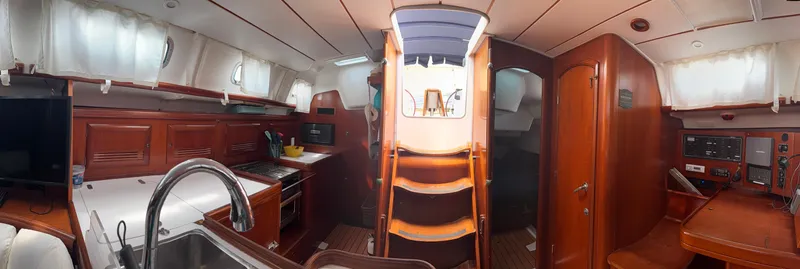 Traveler Yacht Photos Pics Interior of 2002 Beneteau 473 sailboat with wood finish, kitchen, and navigation area.