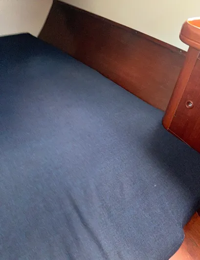Traveler Yacht Photos Pics Interior cabin of 2002 Beneteau 473 sailboat with blue bedding and wooden trim.