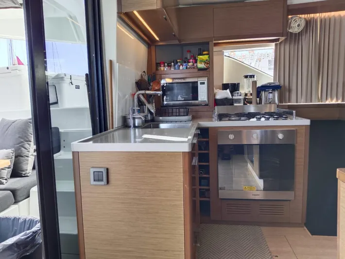  Yacht Photos Pics Modern kitchen interior of 2018 Lagoon 50 yacht with appliances and wooden cabinetry.