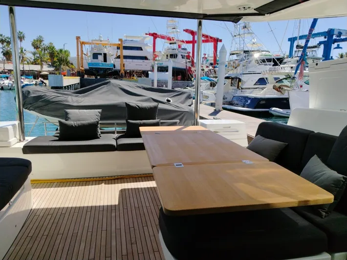  Yacht Photos Pics Spacious deck of 2018 Lagoon 50 yacht with seating and table, docked at marina.