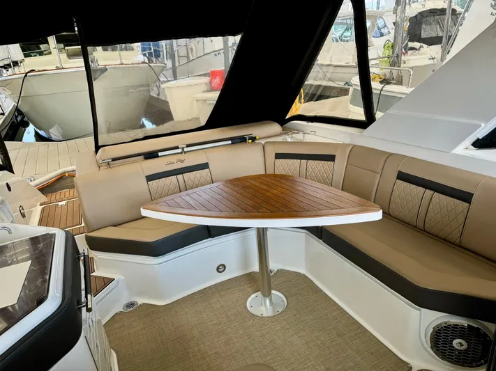  Yacht Photos Pics Interior seating area of 2018 Sea Ray SLX 310 boat with wooden table.