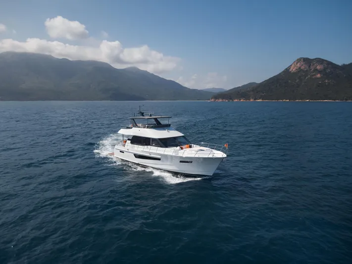  Yacht Photos Pics 2024 CL Yachts CLB65 cruising on open water with scenic mountain backdrop.