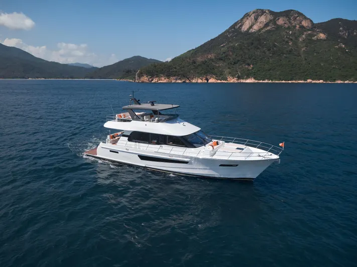  Yacht Photos Pics 2024 CL Yachts CLB65 cruising on blue waters with scenic mountain backdrop.