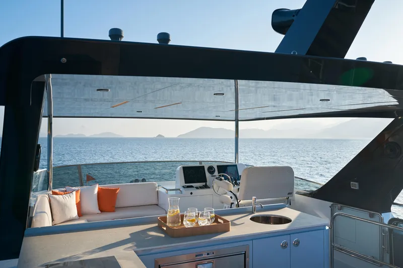  Yacht Photos Pics Luxurious 2024 CL Yachts CLB65 yacht deck with seating, ocean view, and refreshments.