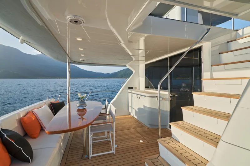  Yacht Photos Pics 2024 CL Yachts CLB65 luxury yacht deck with seating, table, and scenic ocean view.