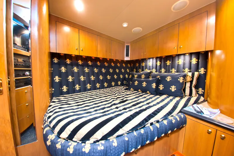  Yacht Photos Pics Luxurious cabin interior of 2000 Buddy Davis 78 yacht with striped bedding and wood cabinetry.