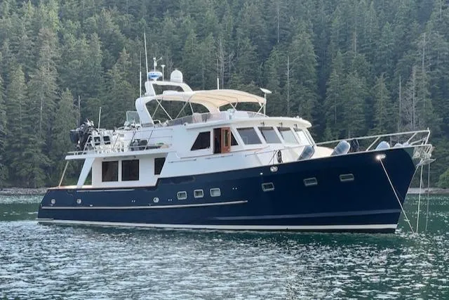 Fellowship Yacht Photos Pics 2001 Grand Alaskan Pilothouse yacht anchored in scenic forested waters.
