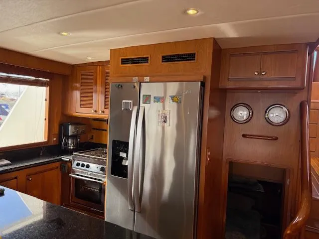 Fellowship Yacht Photos Pics 2001 Grand Alaskan Pilothouse kitchen with stainless steel appliances and wooden cabinetry.