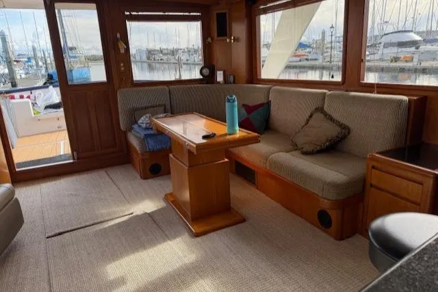 Fellowship Yacht Photos Pics Interior of 2001 Grand Alaskan Pilothouse yacht with cozy seating and marina view.