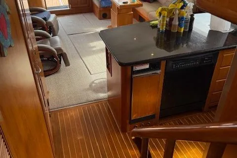 Fellowship Yacht Photos Pics Interior of 2001 Grand Alaskan Pilothouse yacht with wooden flooring and modern kitchen area.