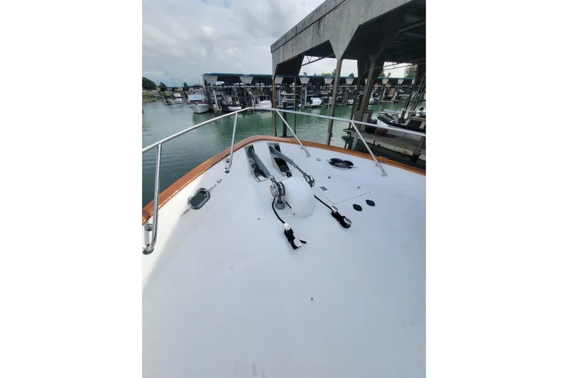 Fellowship Yacht Photos Pics 2001 Grand Alaskan Pilothouse yacht deck at marina, showcasing bow and railing.