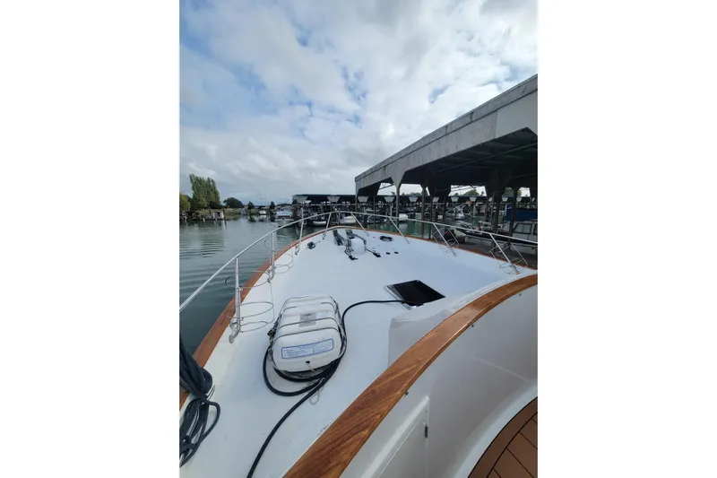 Fellowship Yacht Photos Pics 2001 Grand Alaskan Pilothouse yacht docked at marina under cloudy sky.