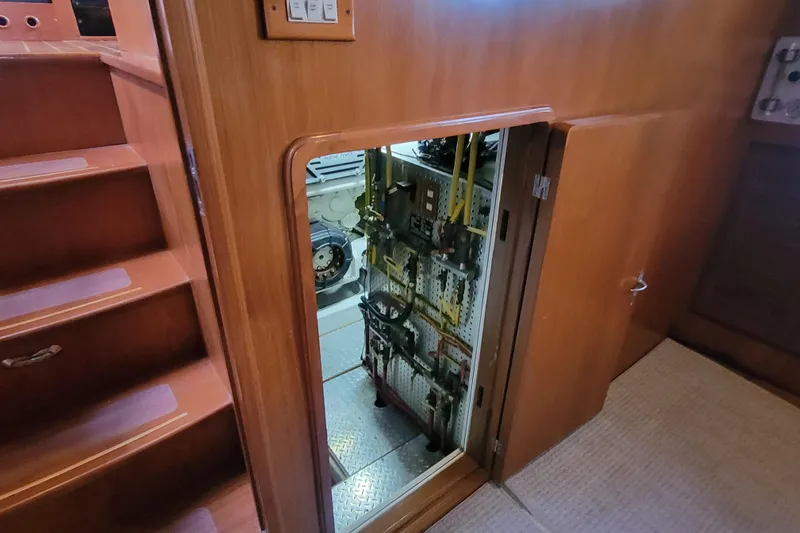 Fellowship Yacht Photos Pics Engine room access on 2001 Grand Alaskan Pilothouse yacht, featuring wooden interior and stairs.