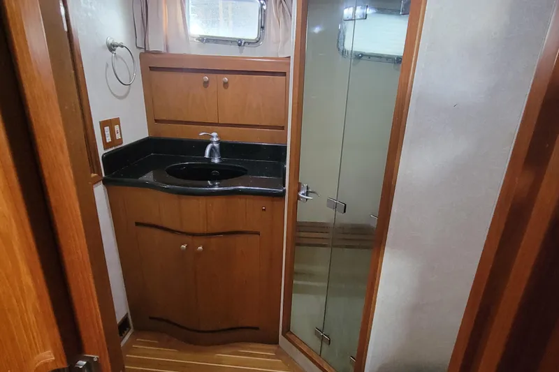 Fellowship Yacht Photos Pics 2001 Grand Alaskan Pilothouse bathroom with wooden cabinetry and glass shower door.