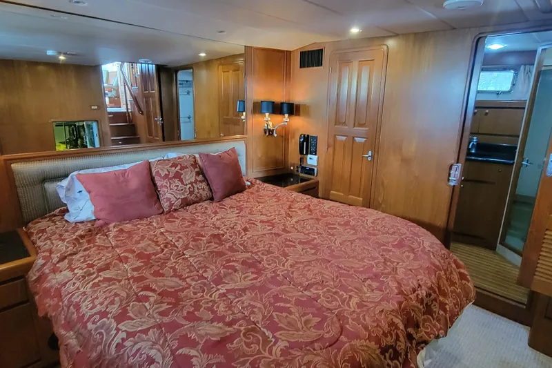 Fellowship Yacht Photos Pics Luxurious bedroom in 2001 Grand Alaskan Pilothouse yacht with elegant wood paneling.