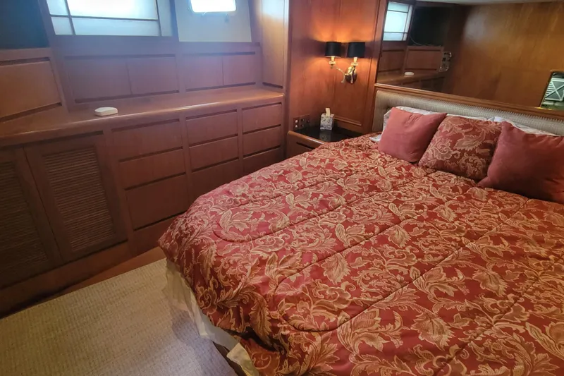 Fellowship Yacht Photos Pics Luxurious bedroom in 2001 Grand Alaskan Pilothouse yacht with elegant bedding and wood paneling.