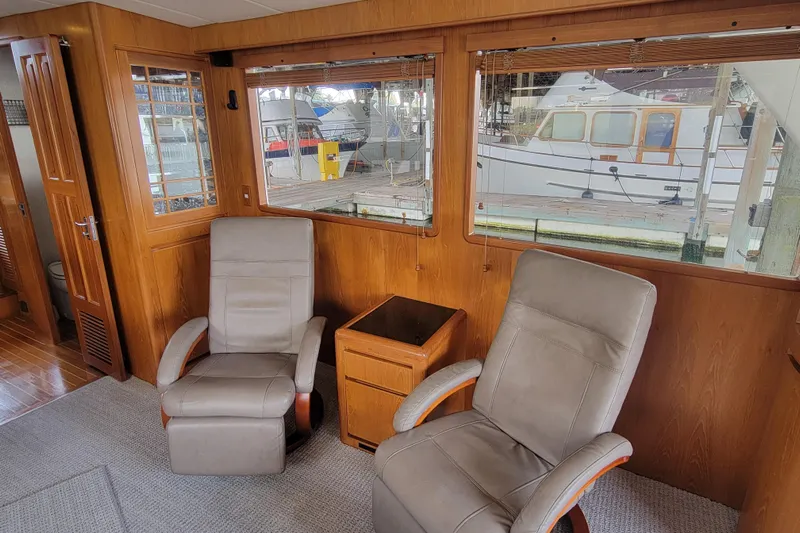 Fellowship Yacht Photos Pics Interior of 2001 Grand Alaskan Pilothouse with two chairs and large windows.