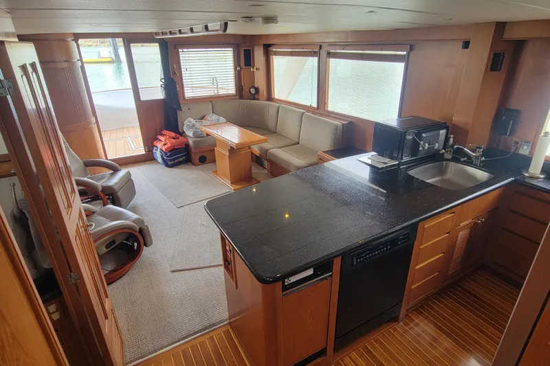 Fellowship Yacht Photos Pics Interior of 2001 Grand Alaskan Pilothouse yacht with kitchen and seating area.