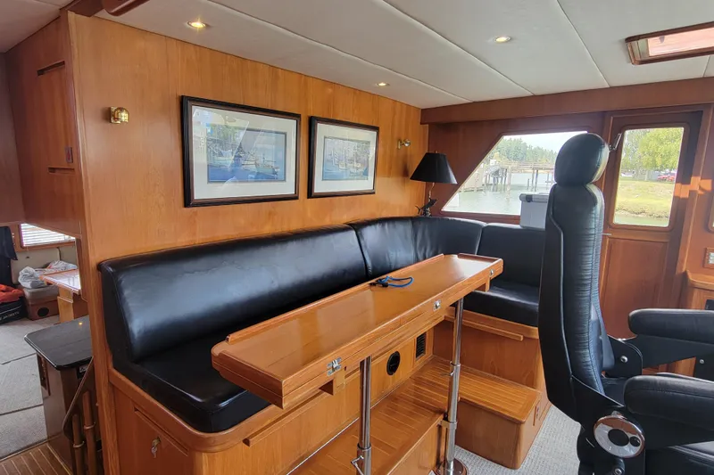 Fellowship Yacht Photos Pics Luxurious 2001 Grand Alaskan Pilothouse interior with leather seating and wooden accents.