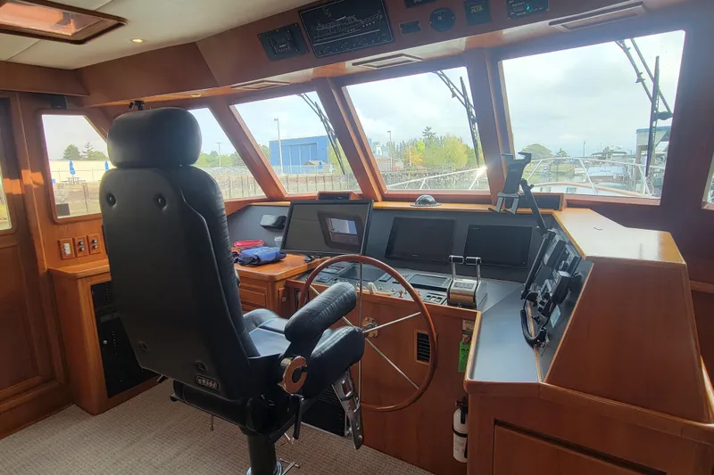 Fellowship Yacht Photos Pics Pilothouse interior of 2001 Grand Alaskan, featuring navigation equipment and captain's chair.