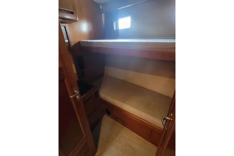 Fellowship Yacht Photos Pics 2001 Grand Alaskan Pilothouse interior with wooden bunk beds and small window.