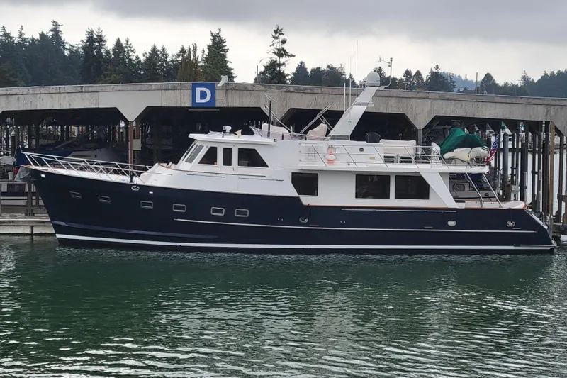 Fellowship Yacht Photos Pics 2001 Grand Alaskan Pilothouse yacht docked at marina under cloudy sky.