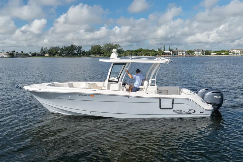 Hi Ho Silver Yacht Photos Pics 2022 Robalo R302 Center Console boat on calm water, under a partly cloudy sky.