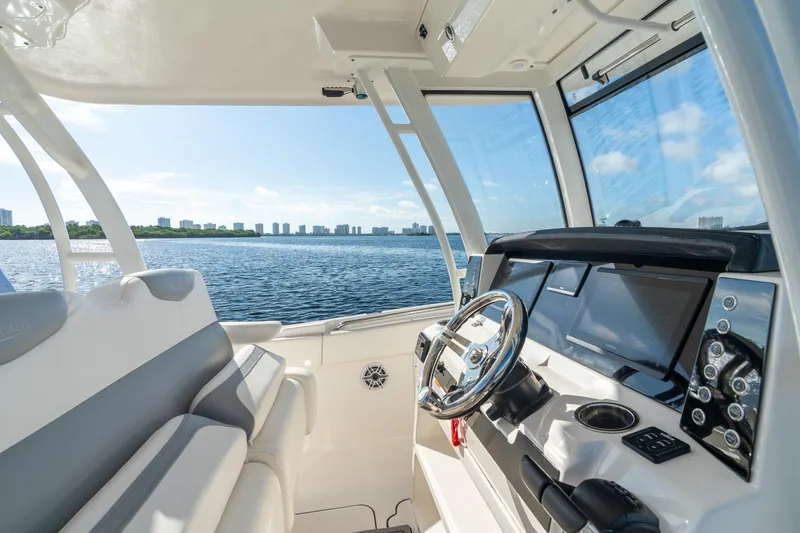 Hi Ho Silver Yacht Photos Pics 2022 Robalo R302 Center Console boat interior with steering wheel and navigation screens.